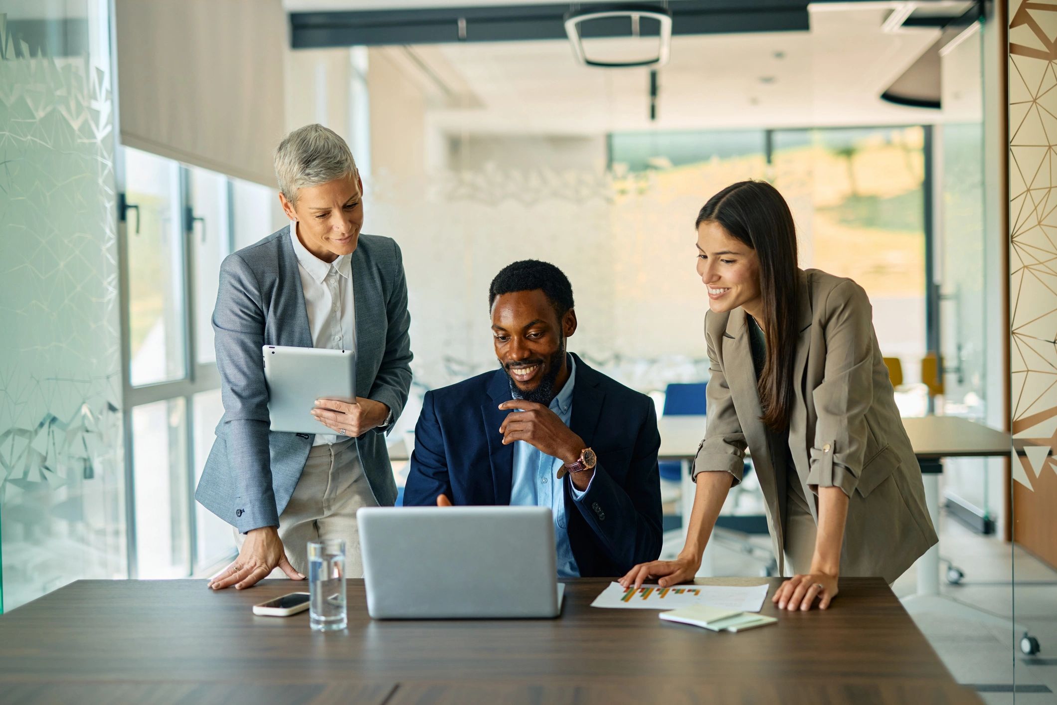 Team collaborating around a laptop in a modern office